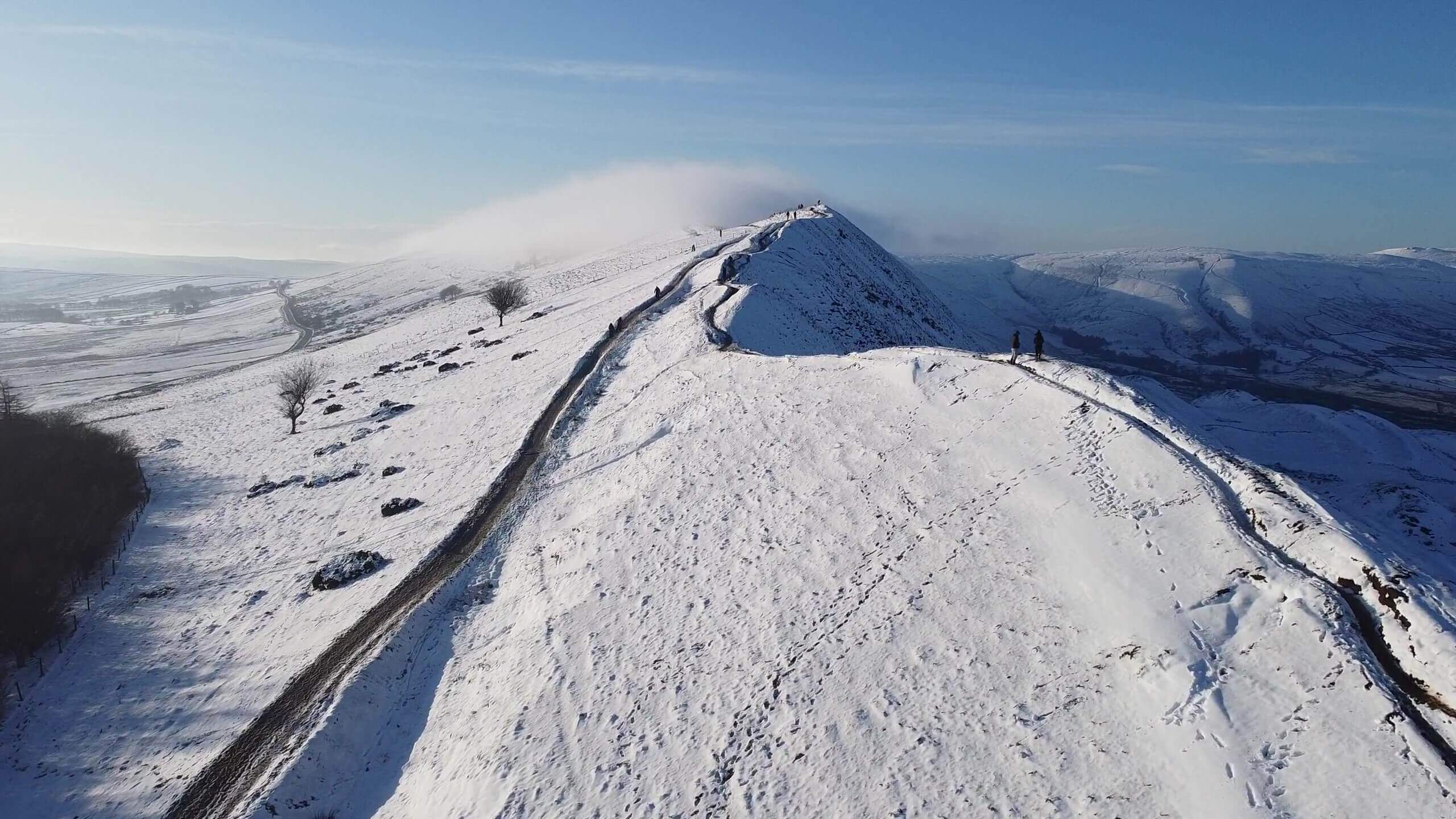 雪山の登山道と奥に広がる山々と空をドローンを使用して撮影した動画